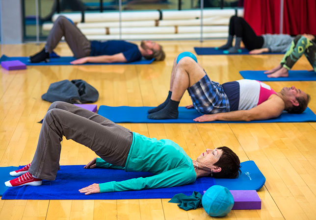 People laying on their backs on yoga mats 